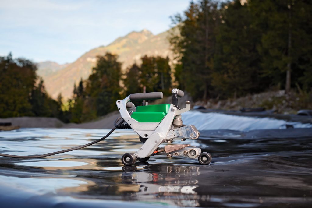 Máquina automática de cuña caliente Leister COMET 700 soldando geomembranas en obra al aire libre