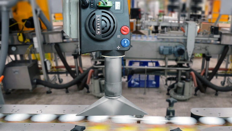 Secado industrial en línea de producción con generador de aire caliente Leister, optimizando velocidad y eficiencia en la fabricación