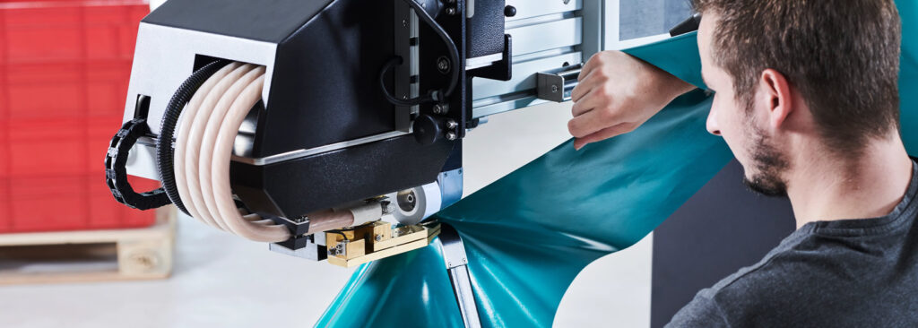 Operario utilizando máquina Leister SEAMTEK para soldar tejidos técnicos con precisión