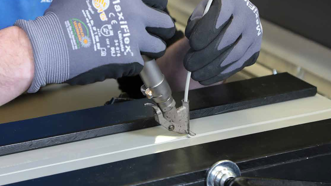 Soldadura manual de plásticos con aire caliente utilizando herramienta Leister, aplicando cordón de soldadura en plancha plástica