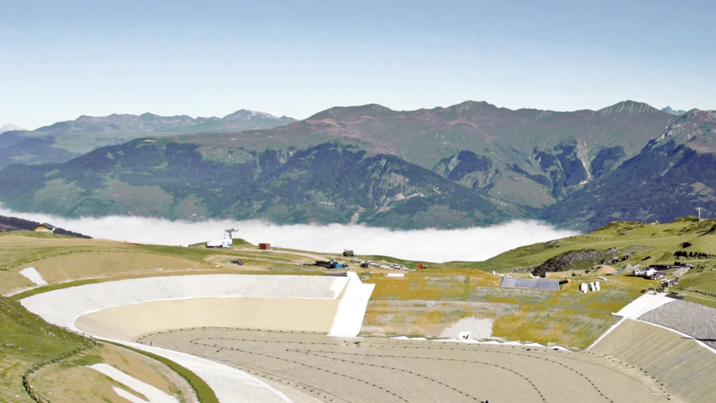 Reservorio de gran escala en zona montañosa con geomembranas impermeables instaladas para almacenamiento de agua