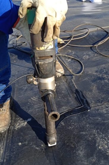 Soldadura de acabados y juntas en geomembranas utilizando una extrusora manual Leister durante la instalación del revestimiento de una laguna