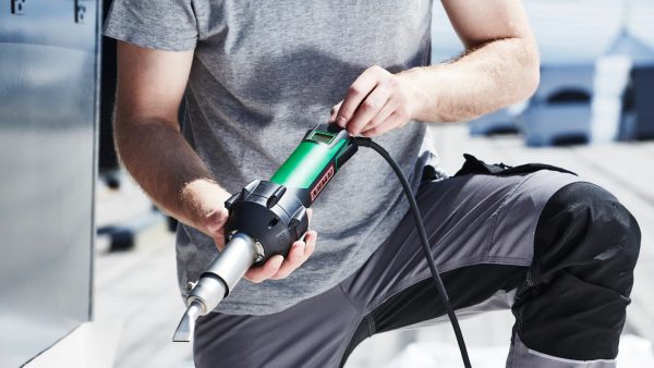 Técnico utilizando el soldador de aire caliente Leister TRIAC-AT, mostrando su diseño ergonómico y ligero ideal para largas jornadas de trabajo