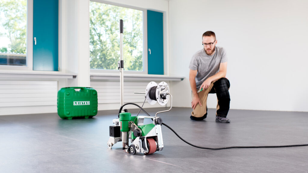 Máquina Leister UNIFLOOR 500 soldando revestimientos de piso con precisión y eficiencia