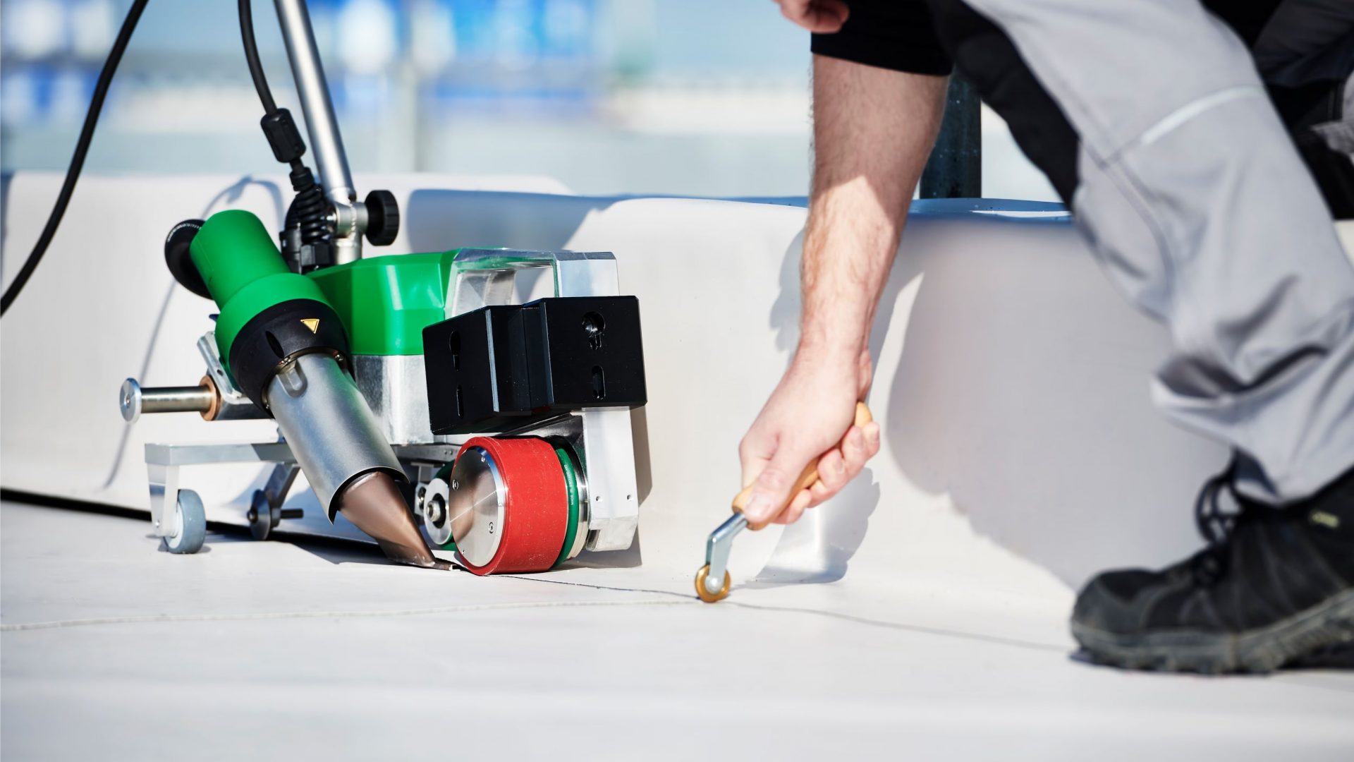 Máquina automática Leister UNIROOF en operación durante la soldadura de membranas TPO en cubiertas planas, acompañada del nuevo rodillo de presión de PTFE de 8 mm