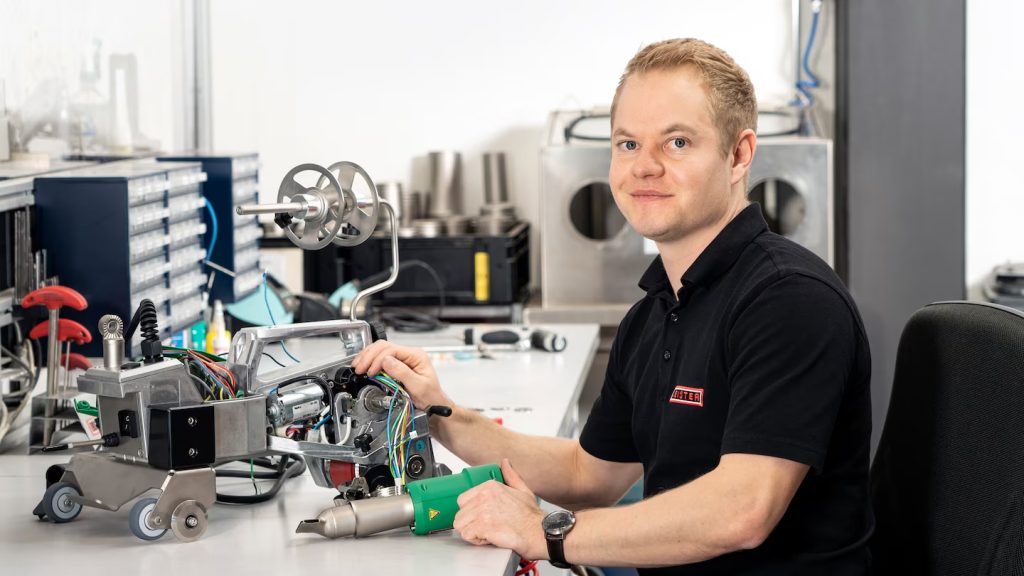 Técnico de Leister trabajando en la reparación de equipos de soldadura plástica con piezas originales Leister