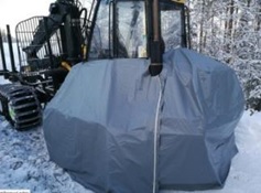 Capa protectora de material resistente cubriendo maquinaria industrial en ambiente frío, protegiéndola de la nieve y el clima extremo