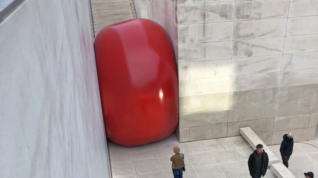 Instalação artística inflável vermelha prensada entre paredes de concreto, criada pela Nasoallinsù e soldada com tecnologia Leister