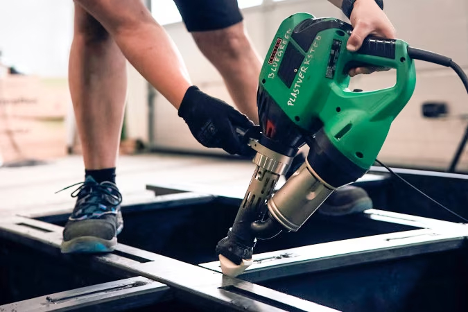 Vista cercana de una extrusora Leister WELDPLAST S2 en operación durante la unión de piezas de polietileno del Marine Donut