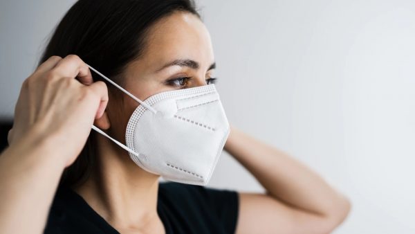 Mujer utilizando una mascarilla médica fabricada con tecnología infrarroja KRELUS de Leister, destacando su uso en el sector médico y farmacéutico