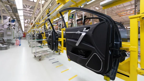 Puertas automotrices en línea de producción, donde el aire caliente se utiliza para conformar y ensamblar plásticos