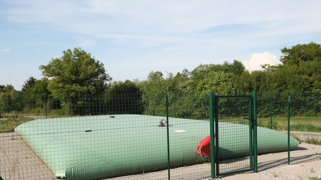 Tanque flexible verde instalado al aire libre para contención de agua u otros fluidos industriales