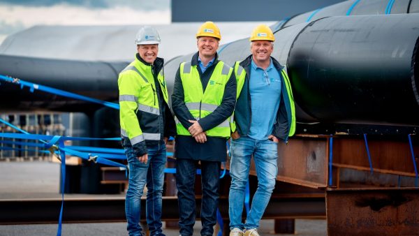 Equipo directivo de Bluegreen — Geir Andresen, Nils-Johan Tufte y Elg Ragnar Thunes — frente a la estructura del Marine Donut construido con extrusoras Leister
