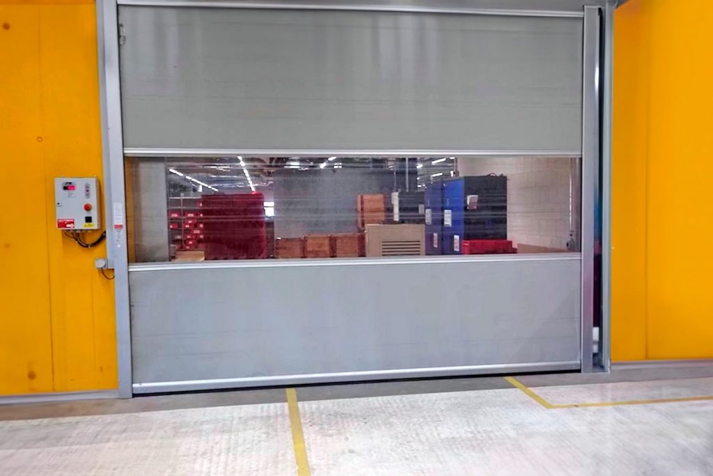 Puerta industrial con paneles de PVC transparente soldada con equipos Leister, ofreciendo máxima resistencia, visibilidad y durabilidad en entornos logísticos