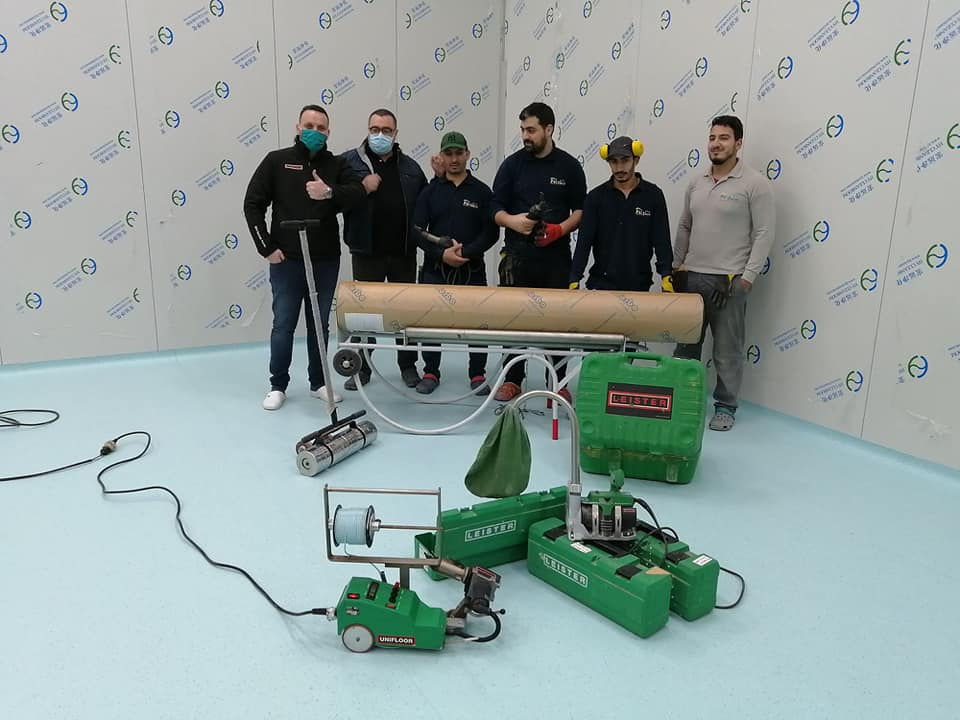 Equipo de instaladores de FS DECO junto a las máquinas Leister UNIFLOOR y GROOVER, destacando su uso en grandes proyectos de pisos en Argelia