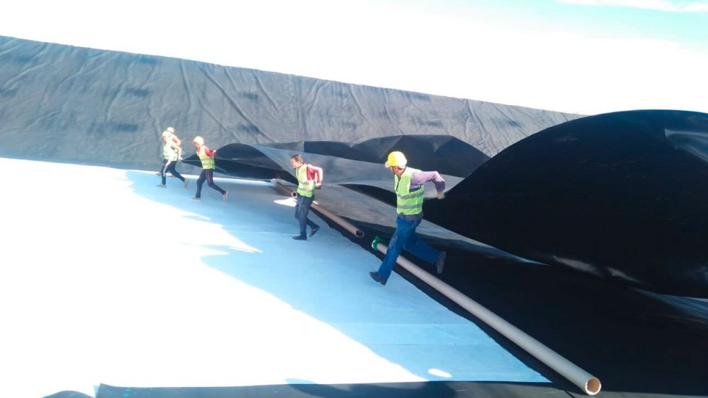 Instalación y extendido de geomembranas PEAD en balsa de riego para cultivos de olivo, mango y limón, realizada por Smart Irrigation con herramientas Leister