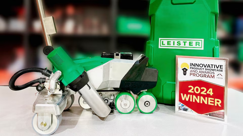Soldadora automática de techos Leister VARIMAT 700 junto a placa de premio “2024 Winner”, destacando el reconocimiento People’s Choice Award