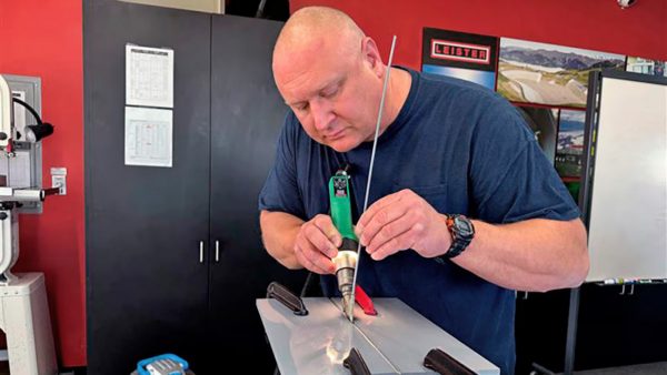 Técnico Dale Moore realizando soldadura de plástico con equipo Leister en mantenimiento de sistemas de agua potable de la AWWU
