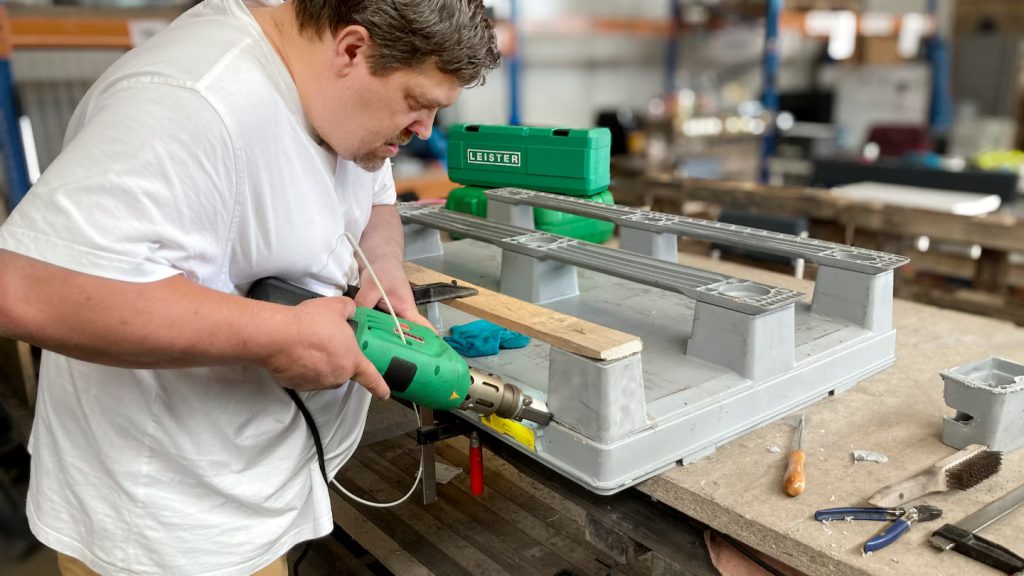 Reparación de palets plásticos dañados mediante soldadura con extrusora Leister FUSION 1, prolongando la vida útil y reduciendo residuos industriales