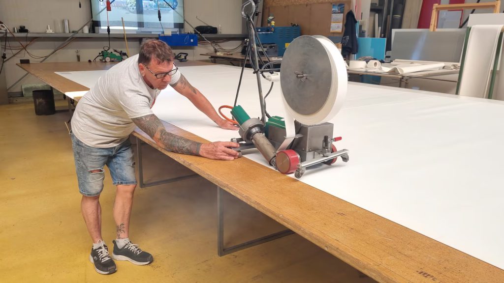 Máquina de soldadura Leister VARIANT S en operación para soldar cintas y lonas en producción continua