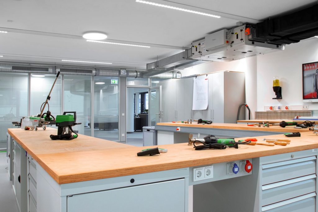 Área de entrenamiento técnico de Leister Academy para aprendizaje práctico de materiales, máquinas y herramientas usadas en cubiertas y pisos