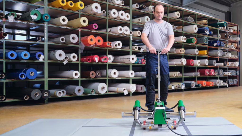 Proceso de soldadura eficiente de lonas con la Leister VARIANT frente a estanterías de materiales