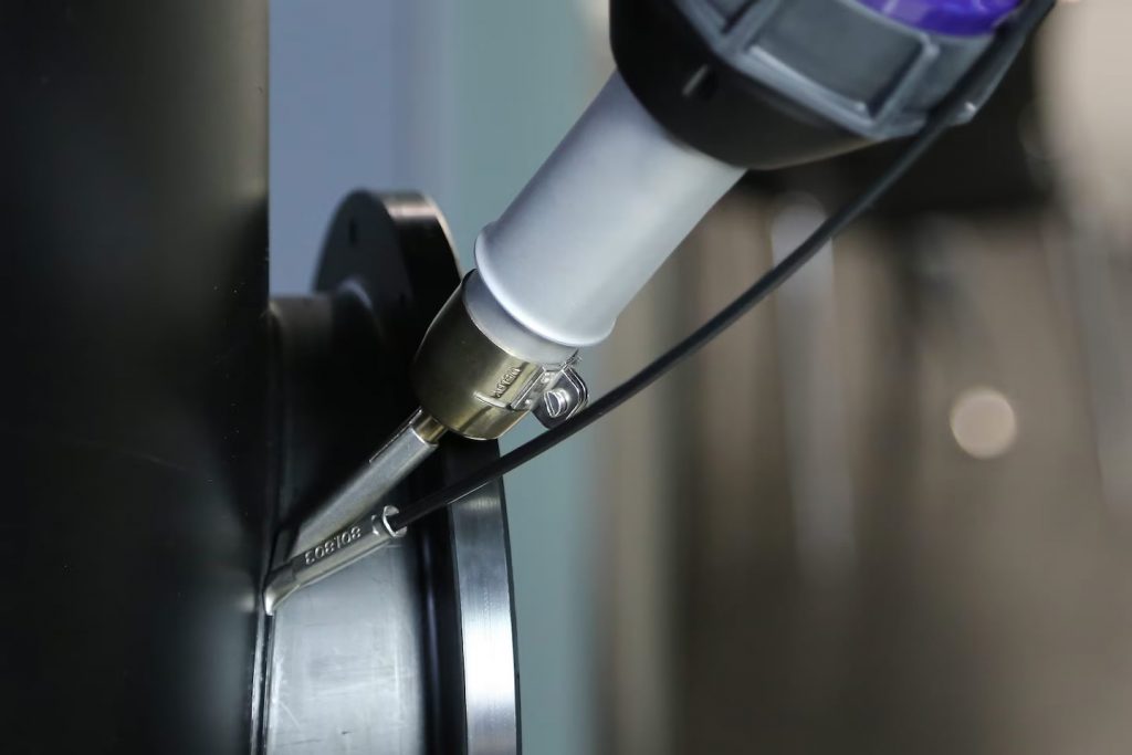 Soldadura de chapas plásticas con el soplador de aire caliente Weldy ENERGY HT1600D, mostrando la boquilla trabajando sobre una placa termoplástica