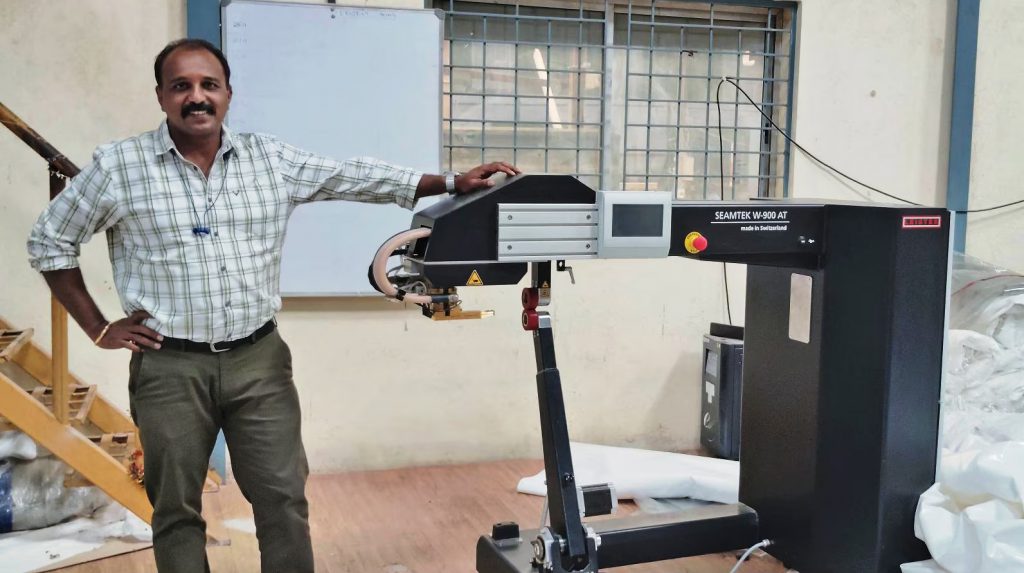 Suresh Chellam, CEO de Skyroof, junto a la máquina Leister SEAMTEK W-900 AT utilizada para duplicar la producción de carpas