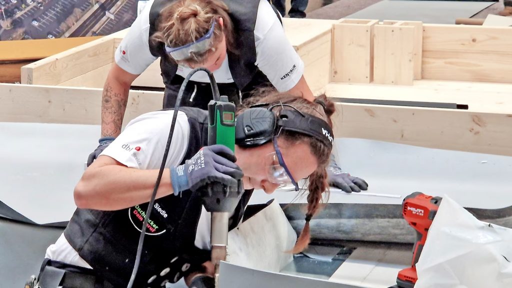 Competidoras realizando soldadura de revestimientos plásticos en techo plano con tecnología Leister durante prueba técnica del Campeonato Mundial en Innsbruck