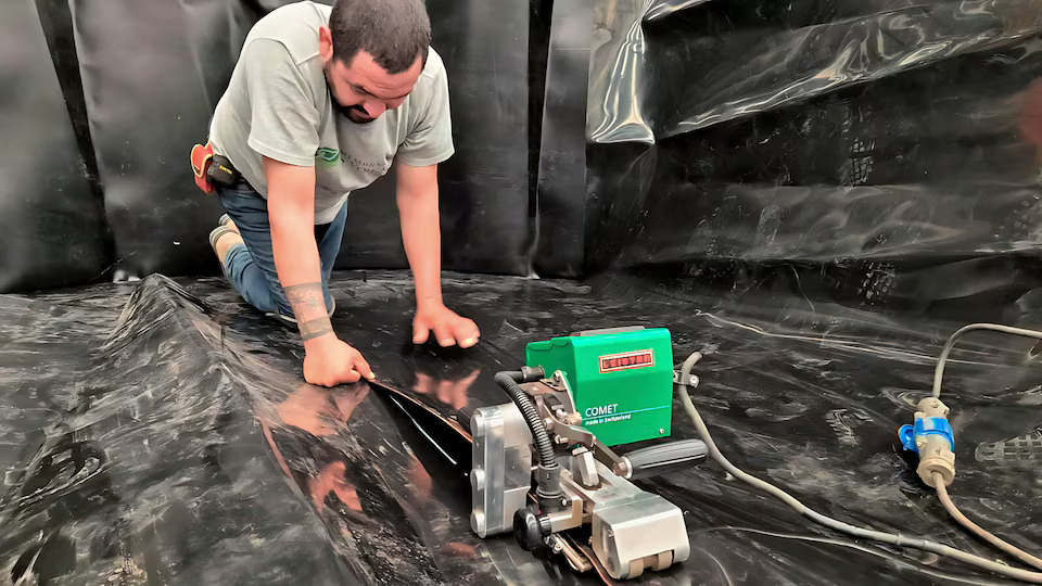 Instalación de geomembrana con soldadora automática Leister COMET para unir láminas con precisión en obra