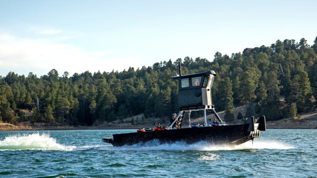 Barco fabricado con PEAD reciclado navegando en un lago, desarrollado por Legacy Innovations con soldadura de plásticos realizada con equipos Leister