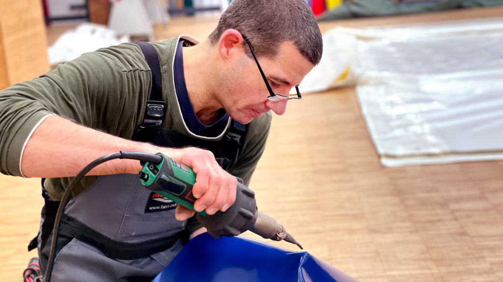 Soldadura manual de lona para camiones con pistola de aire caliente Leister TRIAC en la producción de lonas Fabri-Moll