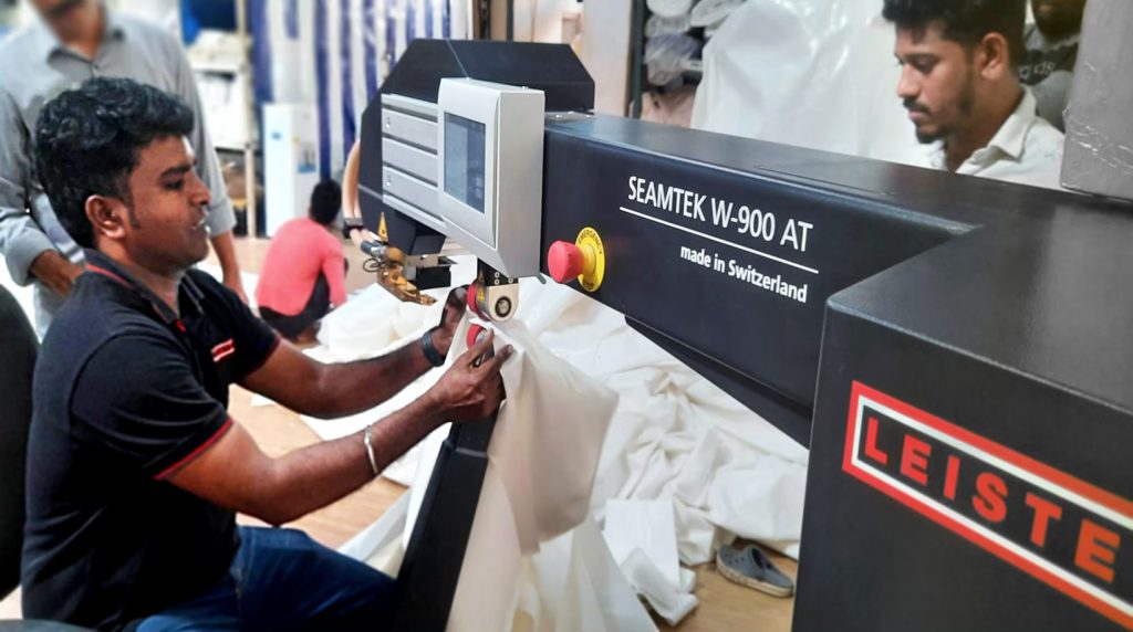 Operario soldando telas de carpa con la máquina Leister SEAMTEK W-900 AT para aumentar la eficiencia de fabricación