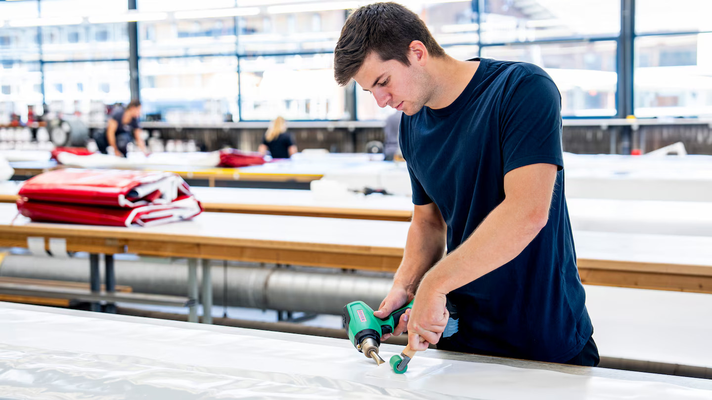 Operario realizando soldadura de material plástico en taller con un soplador de aire caliente inalámbrico Leister NEXHEAT 300 A-LP, asegurando uniones precisas