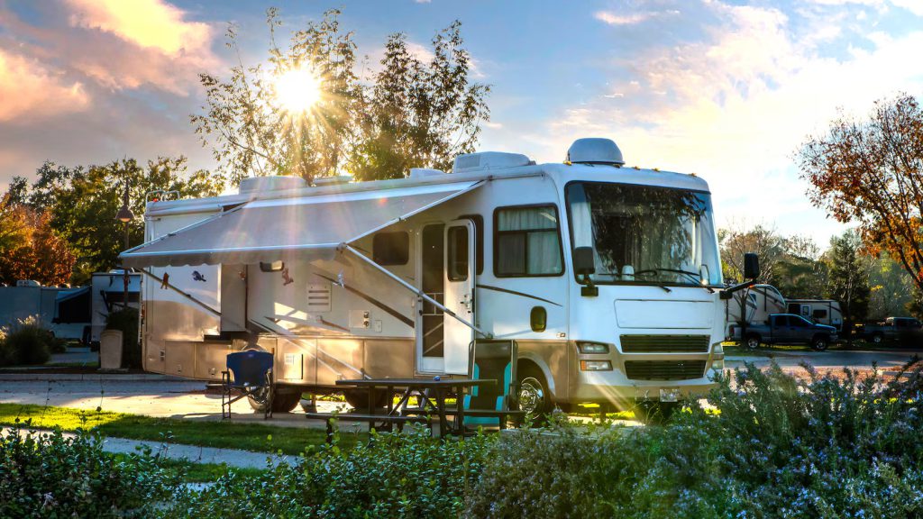 Motorhome estacionado con toldo extendido en un área de camping, instalación y costuras del toldo asociadas a procesos con Leister