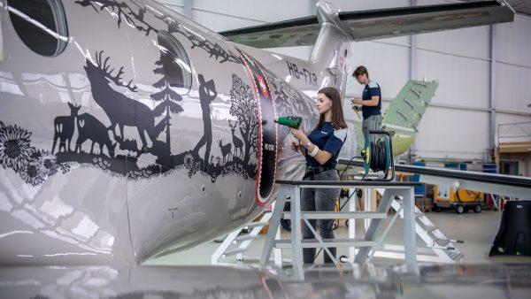 Ploteo técnico de fuselaje de avión con vinilo de alta performance, utilizando equipos Leister para garantizar la adherencia en superficies aeronáuticas curvas
