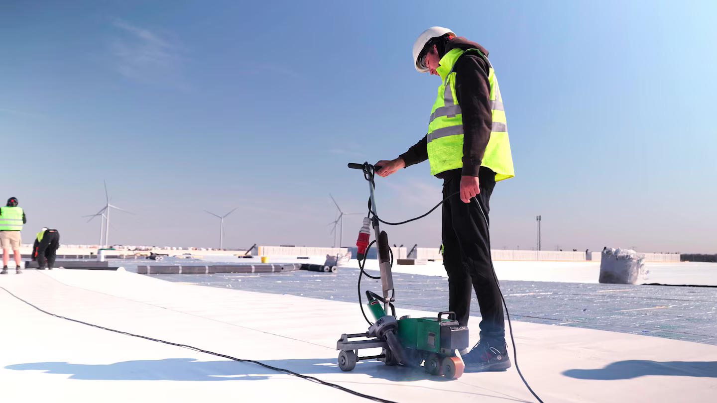 Profesionales de Kamildak supervisando la operación de la soldadora automática Leister para garantizar un sellado uniforme en grandes superficies