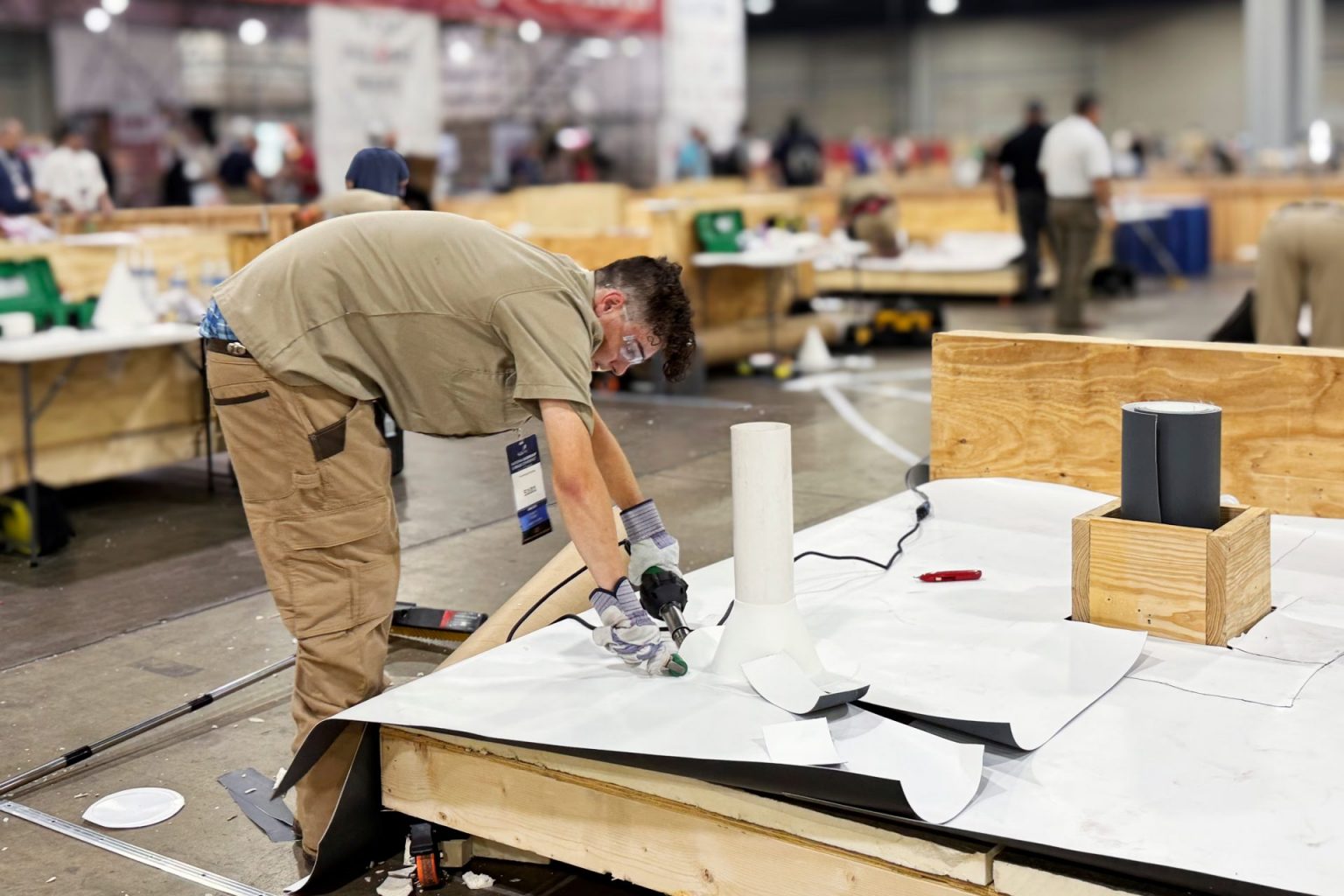 Estudiante realizando una soldadura de precisión con tecnología Leister durante el desafío práctico de la competencia nacional de habilidades en techos