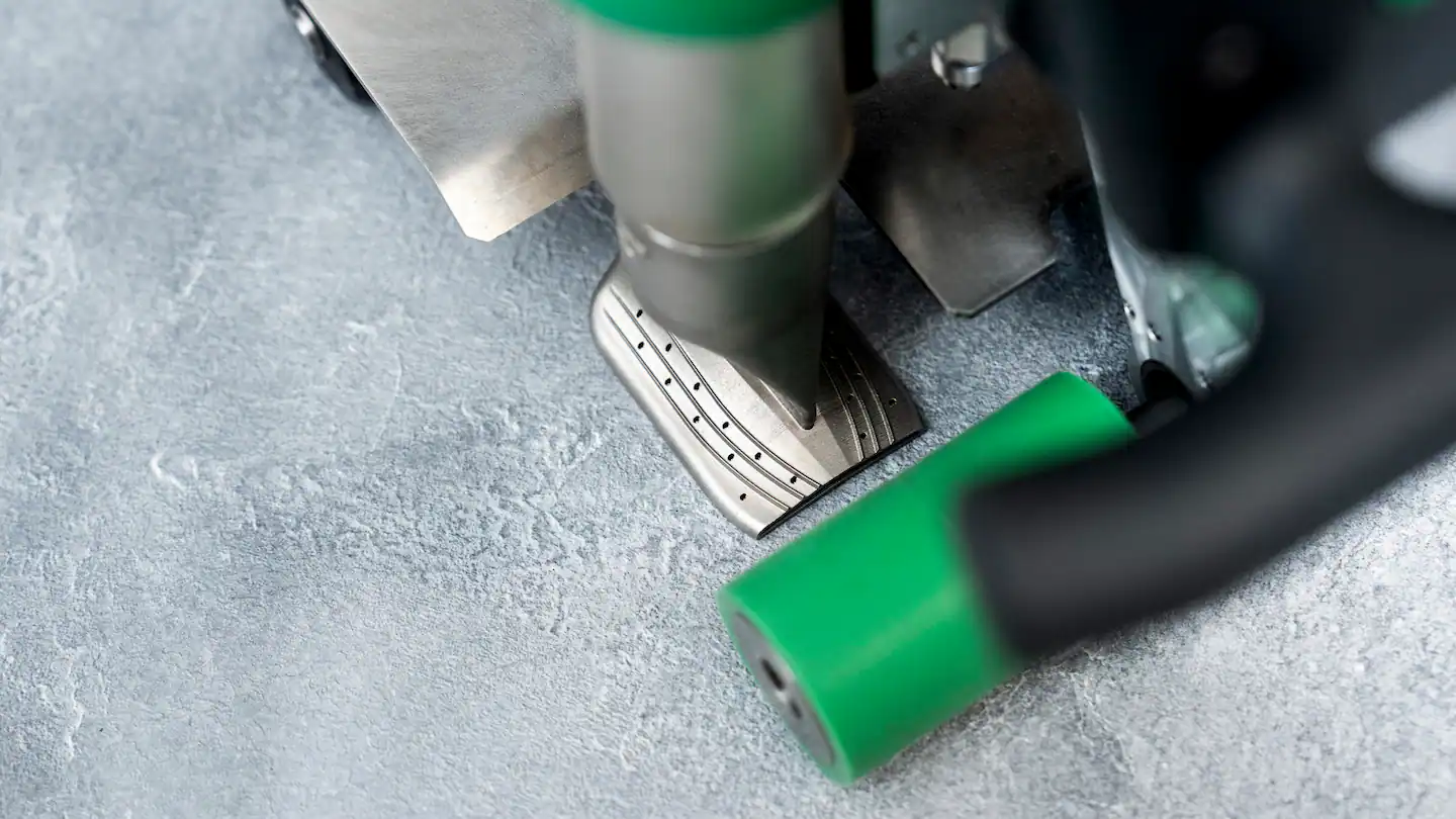 Detalle de la boquilla en T y rodillo de presión de la Leister UNIDRIVE 505 para soldadura a tope en membranas de piscina